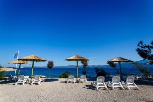 a group of chairs and umbrellas on a beach at Waterman Beach Village in Supetar