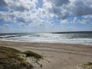 une plage avec l'océan par une journée nuageuse dans l'établissement Luxury Spa Retreat in Thorsminde - By Traum Ferienwohnungen, à Ulfborg 67 autres photos