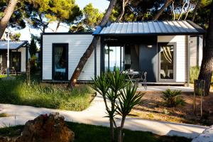 a small white house with a table in a yard at Waterman Beach Village in Supetar