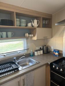 a kitchen with a sink and a stove at Paul’s place silversands in Lossiemouth