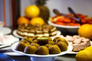 a table with plates of donuts and other foods at Waterman Beach Village in Supetar