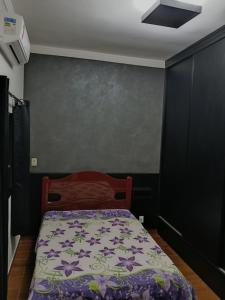 a bedroom with a bed and a gray wall at Casa Encanto in Franca