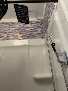 a bathtub with a toothbrush and a shower at Cozy Stay with Pool Relax with Easy Access to Highway in Maxwell