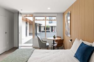 a bedroom with a bed and a table with chairs at Pacific Motor Inn in Mount Maunganui +22 photos