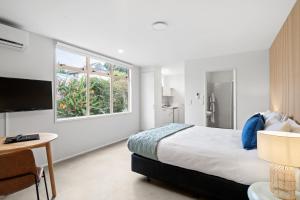 a bedroom with a large bed and a window at Pacific Motor Inn in Mount Maunganui