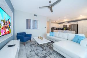 a living room with a white couch and a blue chair at 3151-307BE STOREY LAKE, CONDO 2/2 LAKE VIEW in Kissimmee