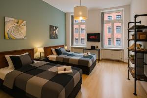 une chambre avec deux lits et une télévision dans l'établissement Leipzig Zentrum, Schnelles WLAN, TVs in allen 5 Zimmern, Self-Check-in, 5 Riesige Zimmer für große Gruppen, Aufzug, à Leipzig