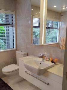 a bathroom with a sink and a toilet and a mirror at The Tawnys in Russell +68 photos