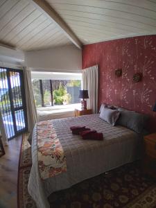 a bedroom with a large bed with a red wall at The Tawnys in Russell