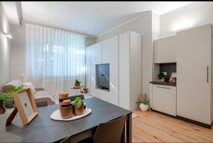 a kitchen and living room with a table and a television at Home Studio Luxury in Milan