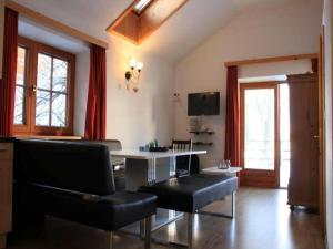 a living room with a table and black leather chairs at Zederhaus in Mariapfarr