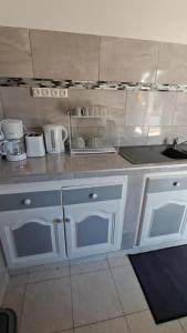 a kitchen with white cabinets and a sink at Kaz'Agatha in Sainte-Anne +11 photos
