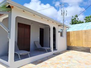 a small house with two chairs on the porch at Kaz'Agatha in Sainte-Anne