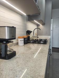 a kitchen counter with a stove and a sink at Apartment in the heart of Joinville in Joinville