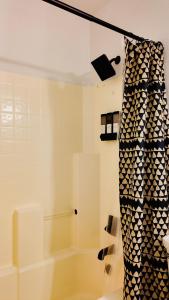 a shower with a black and white shower curtain at Spacious Family Home with AC near Phoenix Stadium in Cashion +26 photos