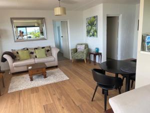 a living room with a couch and a table at Panorama Heights Apartment in Paihia