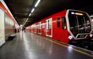 a red train is sitting in a subway station at Home Studio Luxury in Milan