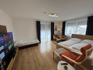 a living room with a bed and a flat screen tv at Daheim, in der Ferne in Schalchham