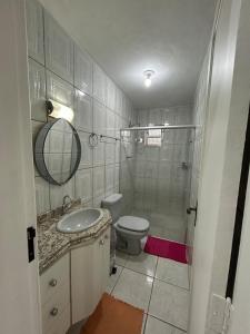 a bathroom with a toilet and a sink and a shower at Apartamento no Centro de Mariana in Mariana +10 photos