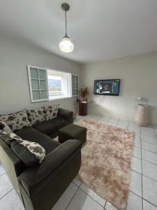a living room with a couch and a tv at Apartamento no Centro de Mariana in Mariana