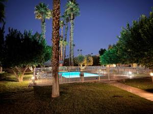 a pool with palm trees in a park at night at Charming & Cozy 2-Bedroom in the Heart of Cathedral City! in Cathedral City