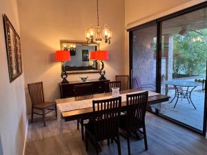 a dining room with a table and chairs and a mirror at Charming & Cozy 2-Bedroom in the Heart of Cathedral City! in Cathedral City