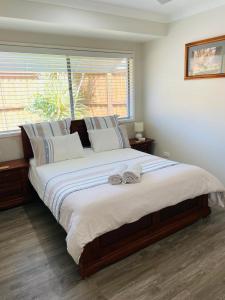 a large bed in a bedroom with a window at Stones Throw at Sapphire in Coffs Harbour