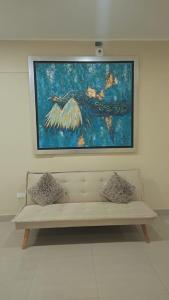 een schilderij aan een muur boven een bankje bij MOON Edificio in San Vicente de Cañete