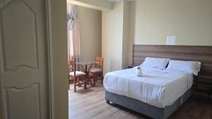 ein Schlafzimmer mit einem Bett, einem Tisch und Stühlen in der Unterkunft MOON Edificio in San Vicente de Cañete