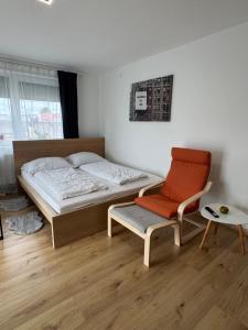 a bedroom with a bed and a chair in it at Daheim, in der Ferne in Schalchham