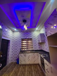 una cucina con luci viola sul soffitto di Kingsville Apartments, Ibadan and Abeokuta a Ibadan