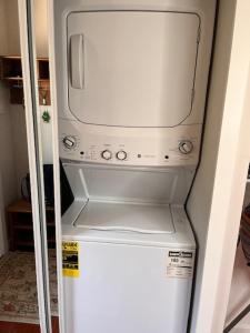 a washer and dryer on top of a refrigerator at Furnished Rooms in North Vancouver