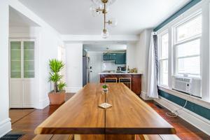 a large wooden table in a room with a kitchen at Prime Location Top Rated Clean Parking Free! in Columbus +50 photos