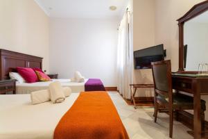 a hotel room with a large bed and a television at Hotel Baco in Seville