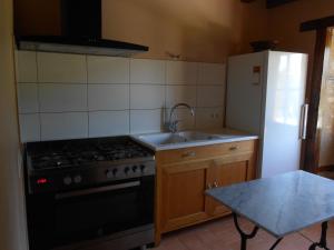 a kitchen with a stove and a sink and a refrigerator at Maison de Caractère Rénovée avec Jardin, Terrasse, et Proche du Château Guillaume - FR-1-591-131 in Lignac +3 photos