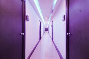 a hallway with purple doors and a long corridor at Hotel O SUN CITY in Vijayawada