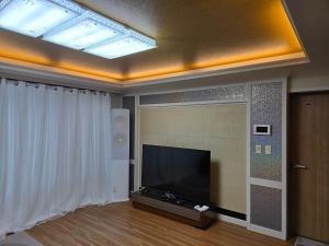 a living room with a flat screen tv on a ceiling at Yeoncho Money Stay in Geoje 