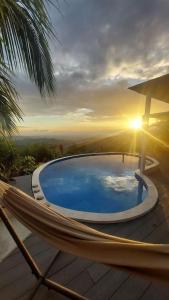 a hammock on a deck with a swimming pool at Palco Pacifico at The Retreat in Atenas