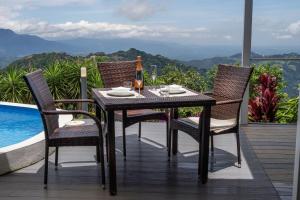 a dining table and chairs on a balcony with a view at Palco Pacifico at The Retreat in Atenas +18 photos