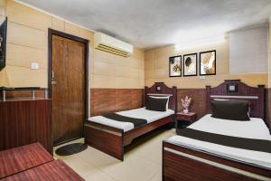 Calcutta Bara BazarにあるHotel O Bhagirathi Guest Houseのベッドルーム1室(ベッド2台、ドア付)