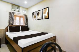 Calcutta Bara BazarにあるHotel O Bhagirathi Guest Houseの壁に2枚の写真が飾られた部屋のベッド1台分です。