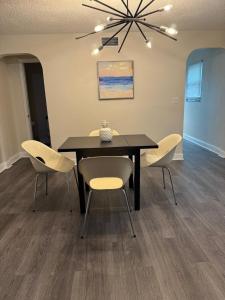 a dining room with a black table and chairs at Sky Accommodation minutes from the airport FLL in Fort Lauderdale +1 photo