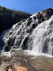 アウト・パライーゾ・デ・ゴイアスにあるQuarto privativo com banheiroの山の斜面にある滝 +2枚の写真