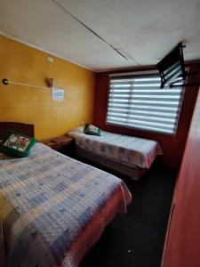 una habitación con dos camas y una ventana en Residencial altamar, en Puerto Montt