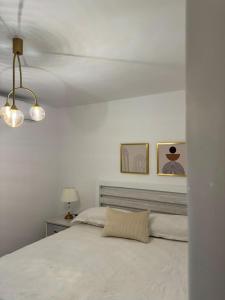 Dormitorio blanco con cama y lámpara en Serena Village E5 AP 203, en Punta Cana