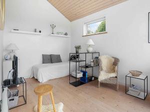 a bedroom with a bed and a chair and a tv at 5 star holiday home in Allingåbro in Rygård Strand