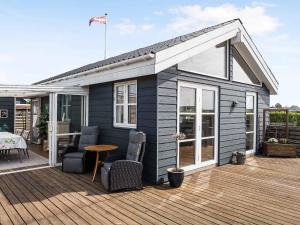 a small house on a deck with a table and chairs at 5 star holiday home in Karrebæksminde in Karrebæksminde