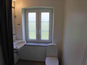a bathroom with a sink and a toilet and a window at 5 star holiday home in Søby Ærø in Soby Mark +9 photos