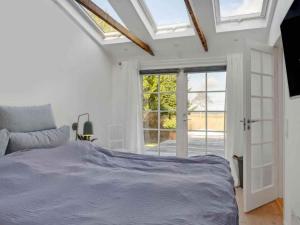 a white bedroom with a bed and a window at 5 star holiday home in Hillerød in Nejede