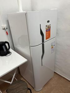 a white refrigerator in a room next to a desk at Cozy House Malbec Route piscina parrilla bici 2 dormitorios in Maipú +22 photos